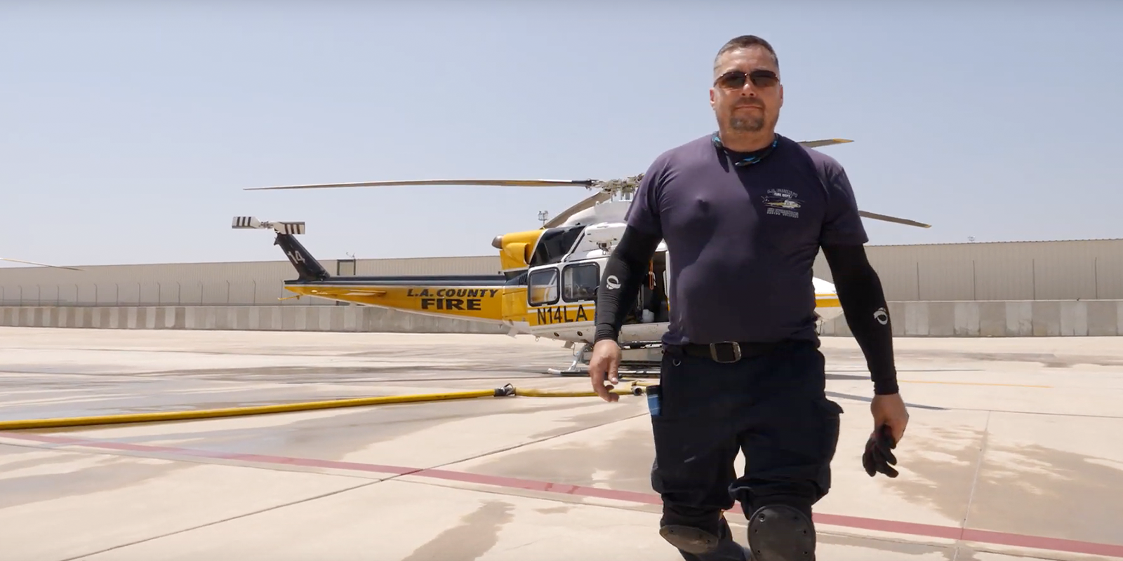 Joe Martinez poses in front of an LA County Fire Department helicopter.