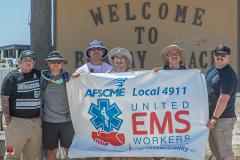 Guillermo and co-workers hold AFSCME Local 4911 banner